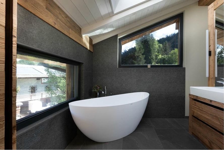 Freestanding bath beside a picture window