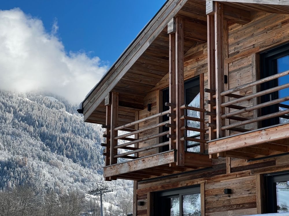 Timber balconies of Chalet Aigle under fresh snow